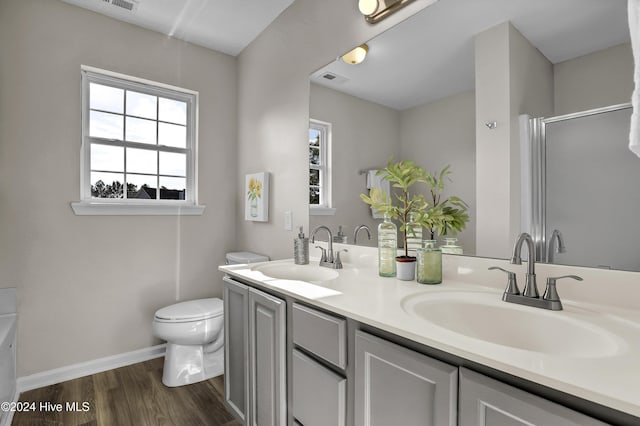 bathroom with toilet, vanity, an enclosed shower, and hardwood / wood-style flooring