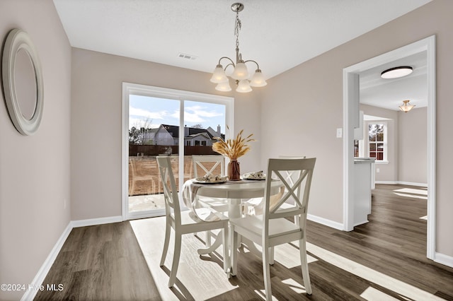 dining room with dark hardwood / wood-style floors and a chandelier