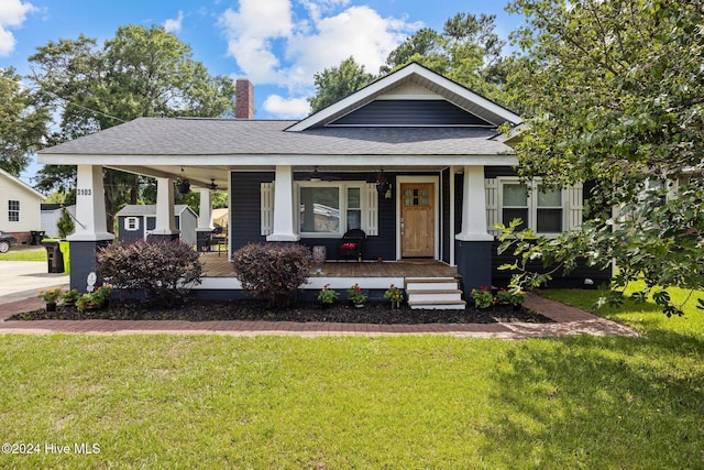 view of front of house featuring ceiling fan, a porch, and a front lawn