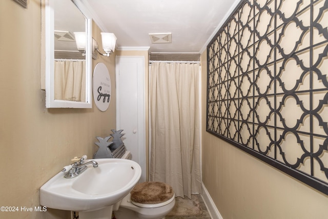 bathroom featuring a shower with curtain, crown molding, sink, and toilet