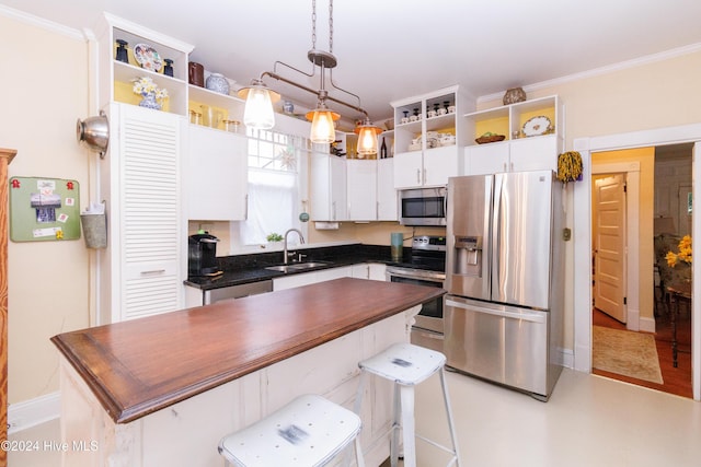 kitchen with appliances with stainless steel finishes, sink, pendant lighting, light hardwood / wood-style flooring, and white cabinets