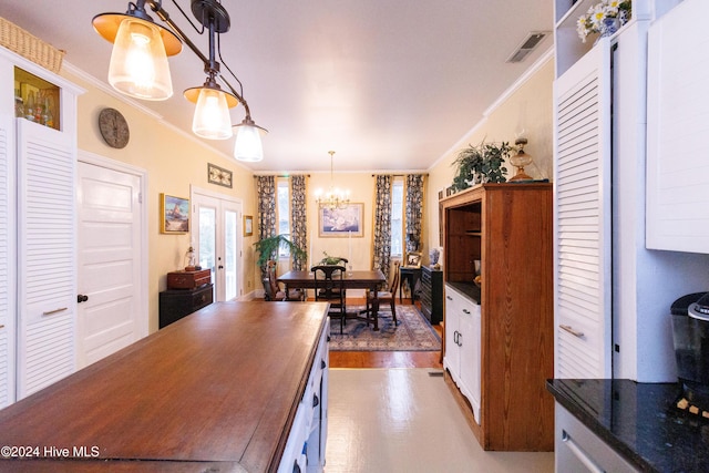 interior space featuring a chandelier, french doors, dark hardwood / wood-style floors, and ornamental molding