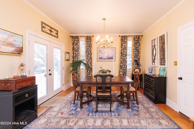 dining room featuring french doors, wood-type flooring, a notable chandelier, and ornamental molding