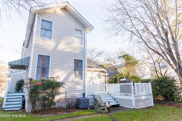 back of property with central AC and a deck