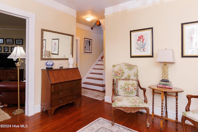 living area featuring dark hardwood / wood-style flooring and ornamental molding