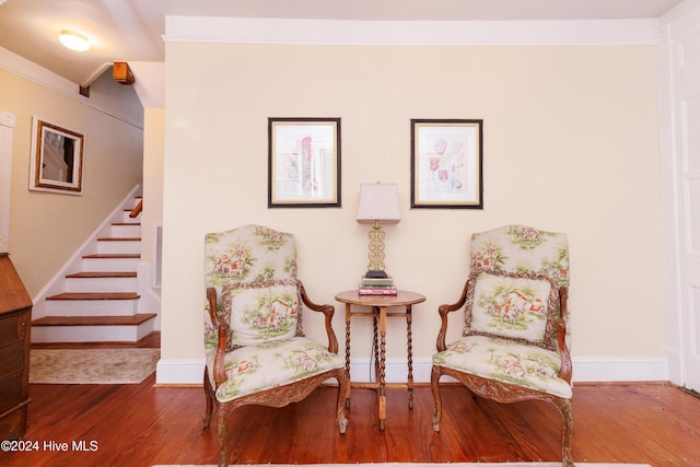 sitting room with wood-type flooring and crown molding