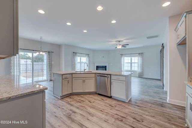 kitchen featuring dishwasher, decorative light fixtures, a kitchen island, and a healthy amount of sunlight