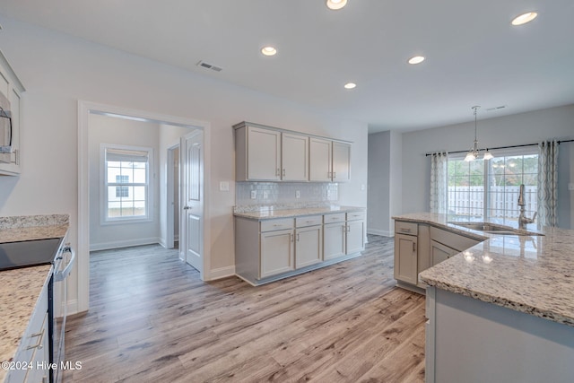 kitchen featuring a wealth of natural light, sink, and light hardwood / wood-style floors