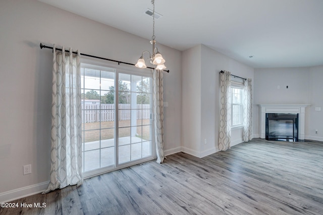 interior space featuring light wood-type flooring, a wealth of natural light, and a notable chandelier