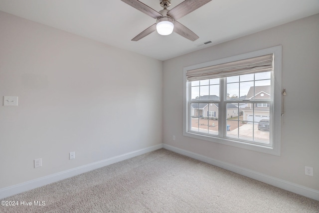 carpeted spare room featuring ceiling fan