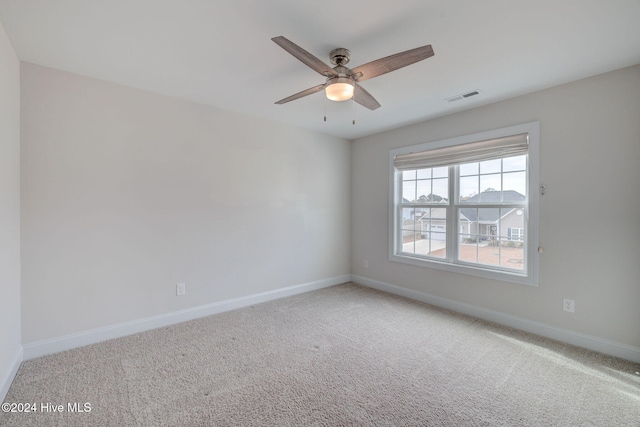 carpeted spare room featuring ceiling fan