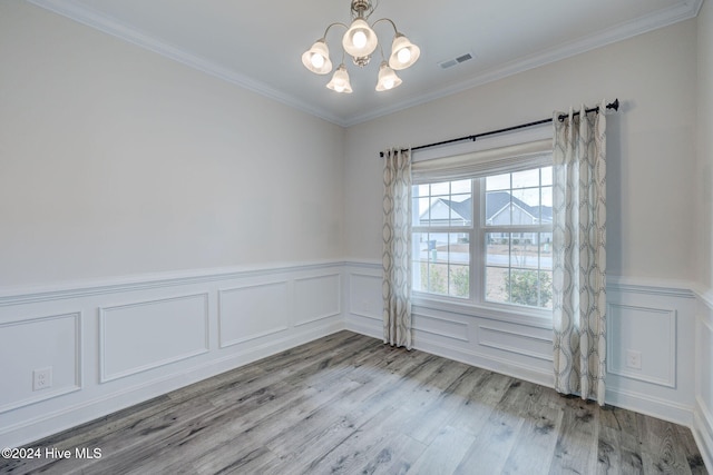 unfurnished room with ornamental molding, light hardwood / wood-style flooring, and a chandelier