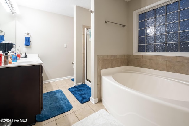 bathroom with tile patterned flooring, vanity, and shower with separate bathtub