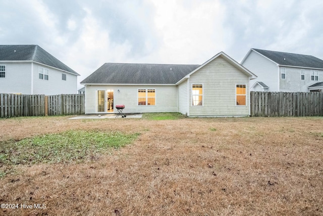 rear view of house with a lawn and a patio area