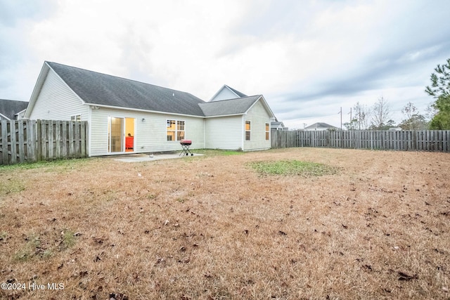 back of property with a yard and a patio