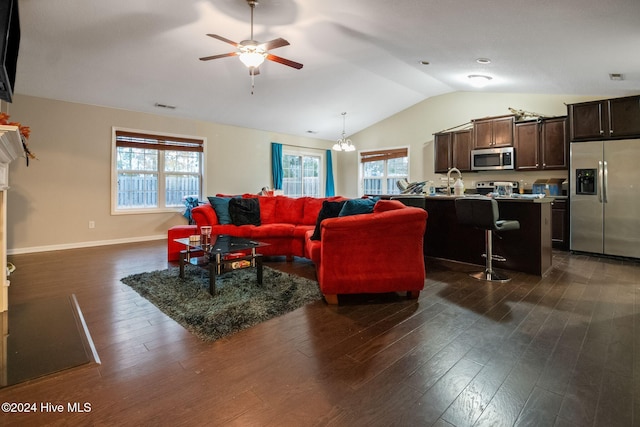 living room with dark hardwood / wood-style floors, lofted ceiling, and ceiling fan with notable chandelier