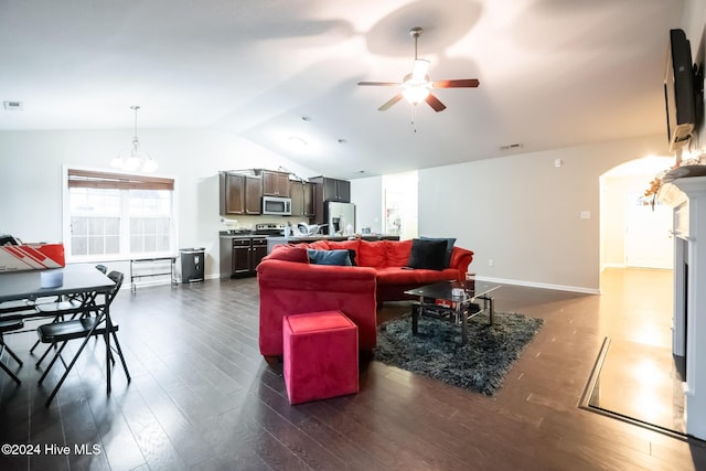 living room with ceiling fan with notable chandelier, dark hardwood / wood-style floors, and lofted ceiling