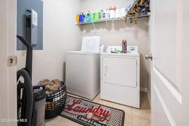 laundry area featuring washing machine and clothes dryer, electric panel, and light tile patterned flooring