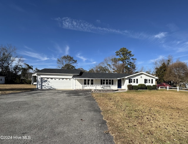 ranch-style house with a porch, a garage, and a front lawn