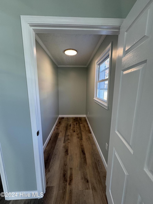 corridor with dark hardwood / wood-style floors and ornamental molding