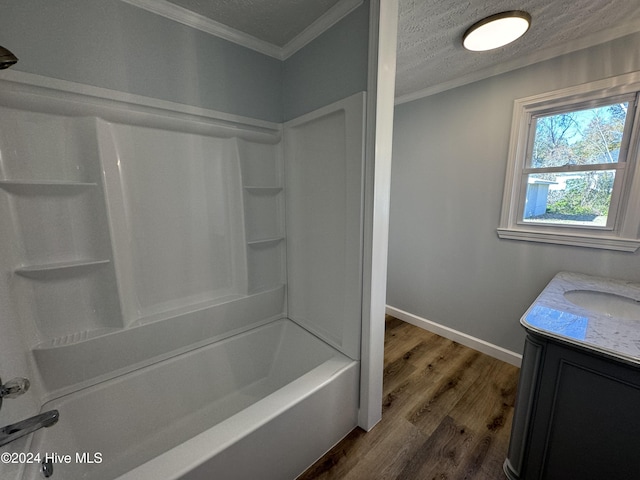 bathroom featuring hardwood / wood-style flooring, shower / bathtub combination, crown molding, and a textured ceiling