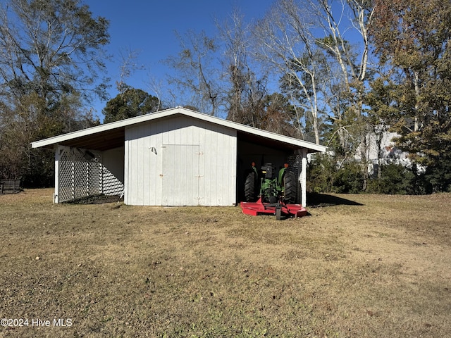 view of outbuilding with a lawn and a carport