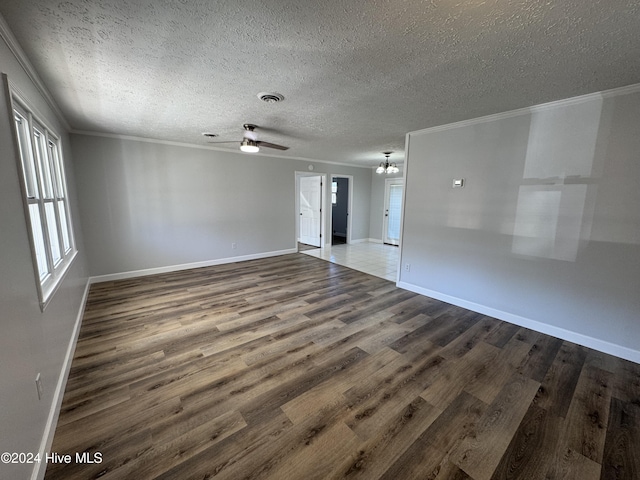 spare room featuring ceiling fan with notable chandelier, wood-type flooring, a textured ceiling, and ornamental molding