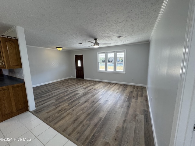 unfurnished living room with light hardwood / wood-style floors, a textured ceiling, and ornamental molding