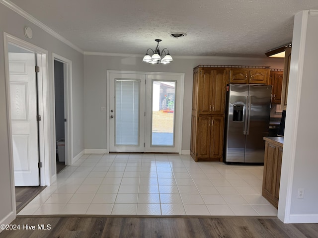 kitchen with stainless steel fridge with ice dispenser, hanging light fixtures, light hardwood / wood-style floors, and ornamental molding