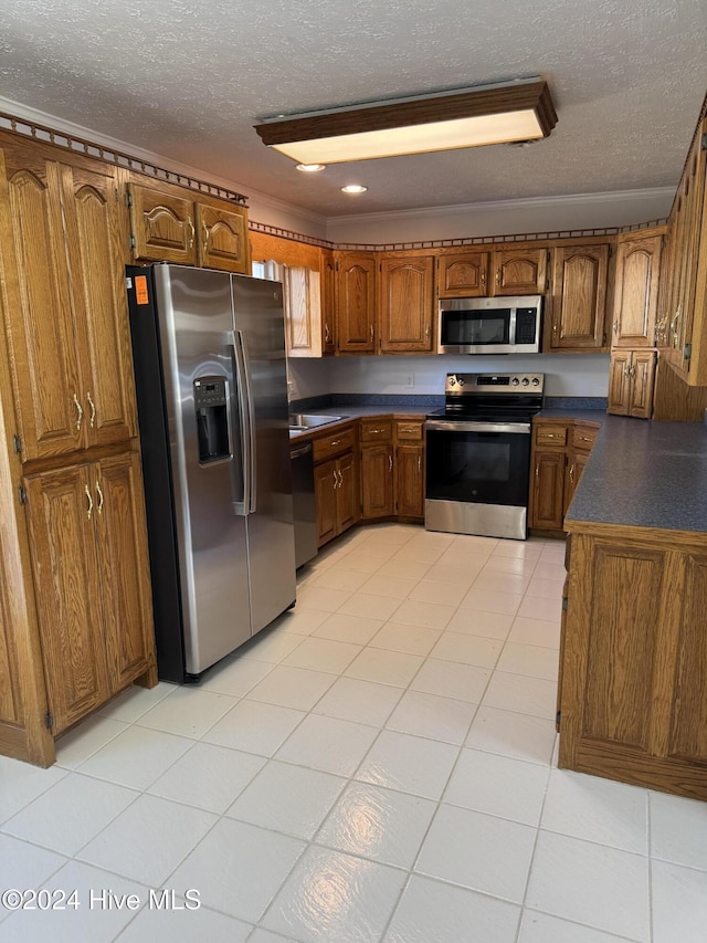 kitchen featuring a textured ceiling, light tile patterned floors, and stainless steel appliances