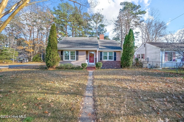 ranch-style home with a front yard and central air condition unit