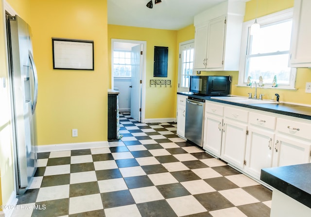 kitchen with white cabinets, decorative light fixtures, sink, and stainless steel appliances