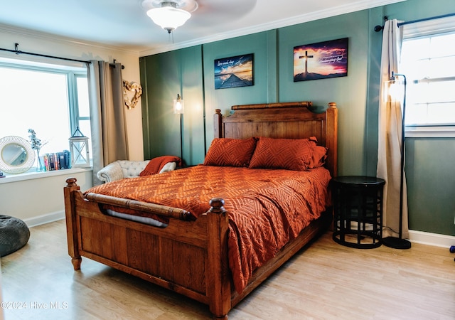 bedroom featuring ceiling fan, light hardwood / wood-style floors, and ornamental molding