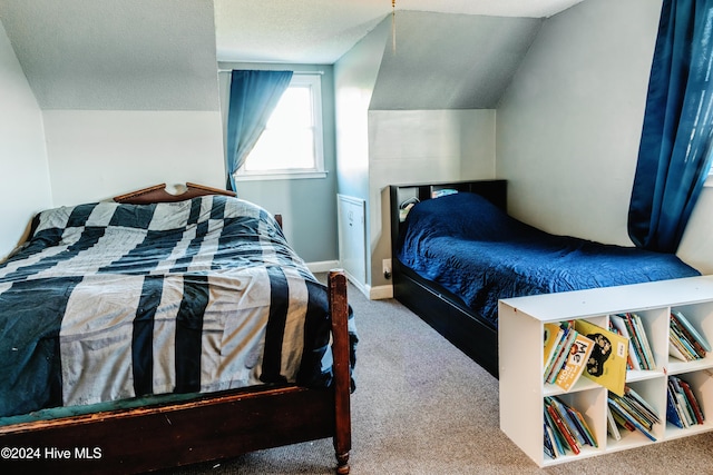 bedroom featuring a textured ceiling, carpet, and lofted ceiling