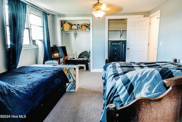 carpeted bedroom featuring a textured ceiling and ceiling fan