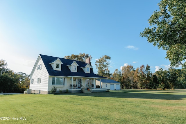 cape cod house featuring central air condition unit, a front lawn, a garage, an outbuilding, and a porch