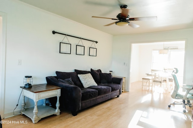 living room with light wood-type flooring, ceiling fan, and ornamental molding