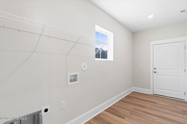 clothes washing area featuring electric dryer hookup, hardwood / wood-style floors, hookup for a washing machine, and hookup for a gas dryer