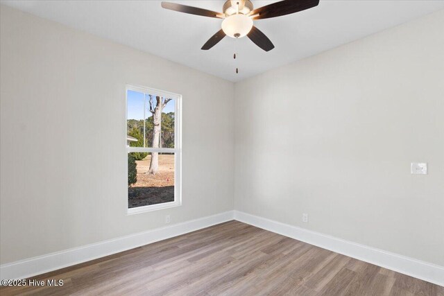 unfurnished bedroom featuring connected bathroom, a spacious closet, a raised ceiling, and light wood-type flooring