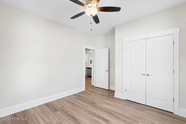 unfurnished room featuring ceiling fan, a raised ceiling, and light hardwood / wood-style floors