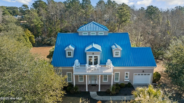 view of front of home with a garage, french doors, metal roof, and a standing seam roof