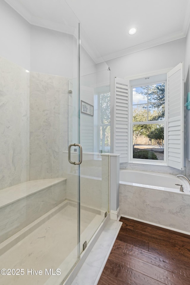 bathroom featuring a stall shower, wood-type flooring, a garden tub, and crown molding