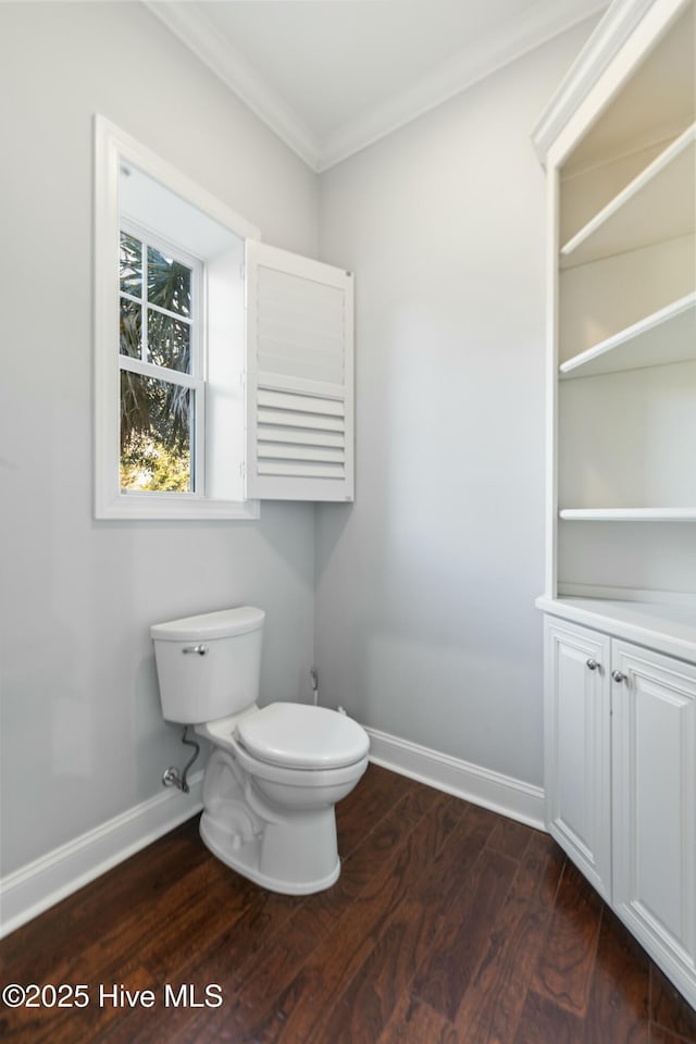 bathroom featuring ornamental molding, toilet, baseboards, and wood finished floors