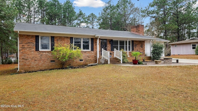 single story home featuring a front yard, crawl space, brick siding, and a chimney