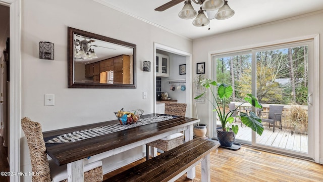 dining area with light wood finished floors, visible vents, a ceiling fan, and ornamental molding