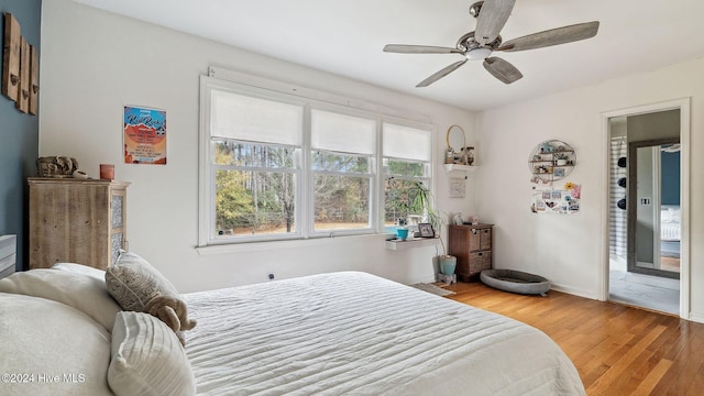 bedroom with ceiling fan, baseboards, and wood finished floors