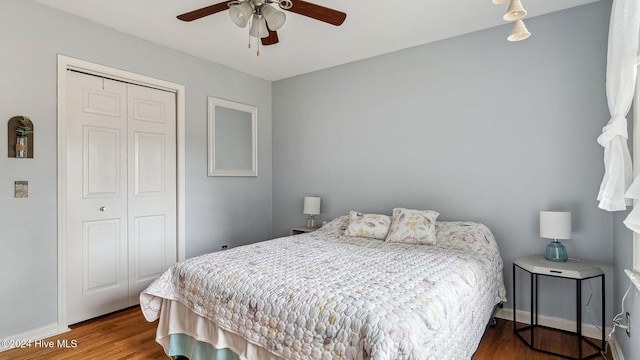 bedroom featuring a ceiling fan, a closet, baseboards, and wood finished floors