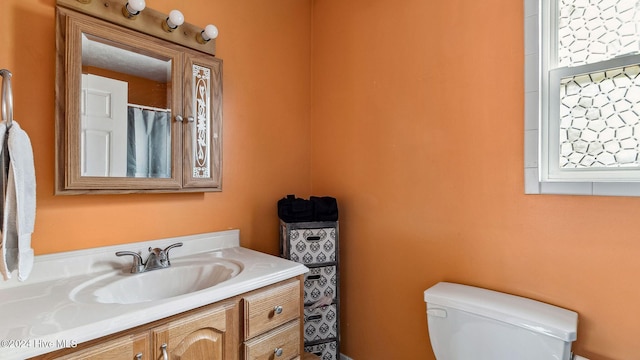 full bathroom with toilet, plenty of natural light, and vanity