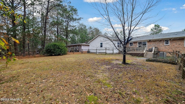 view of yard featuring a fenced backyard, a deck, and stairs