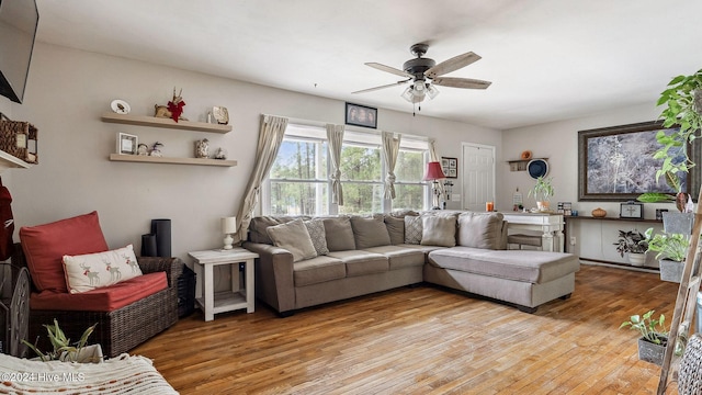 living room featuring light wood finished floors and a ceiling fan